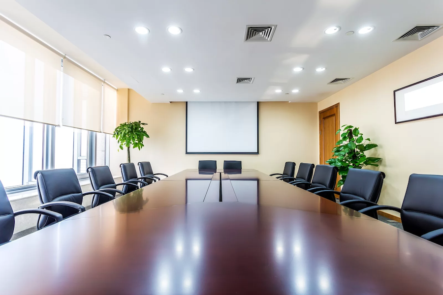 Beautiful, light conference room design with motorized shades, lights, and AV equipment. 