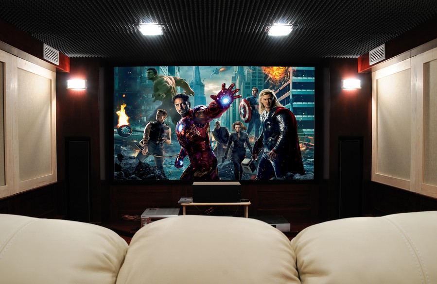 Custom home theater with plush white seating and a large format projections screen with a Marvel movie showing