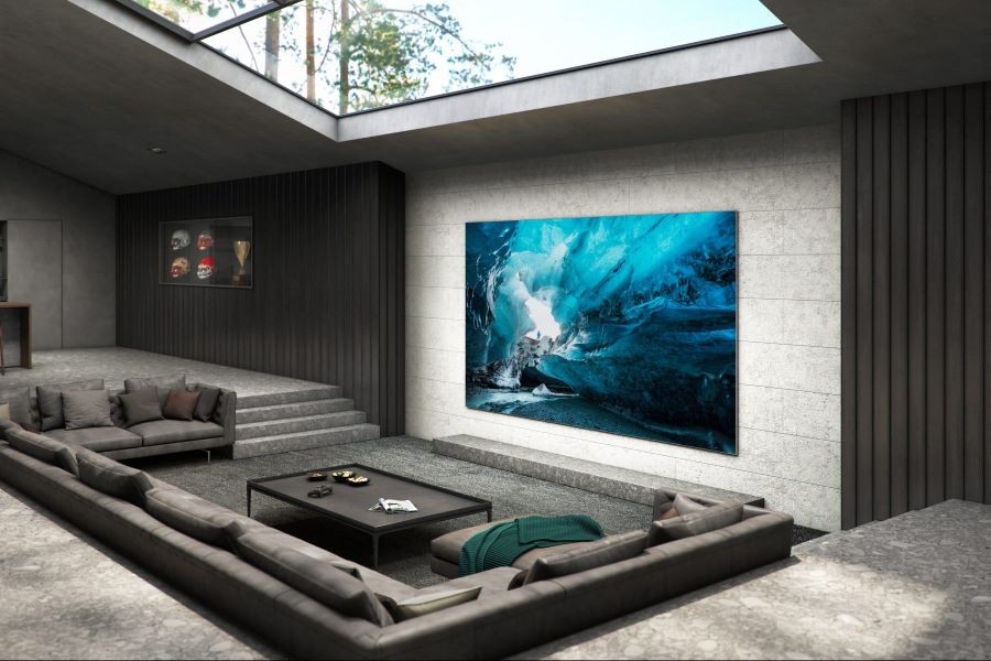 A room with a large flat-screen TV and a sunken sectional. 