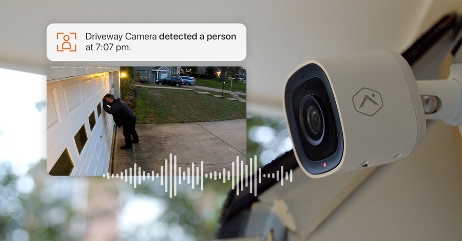 Security camera footage of a man looking into a garage door window with a text alert about the incident above it.