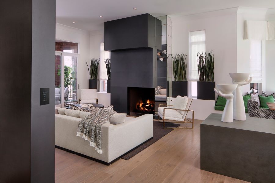 A Crestron Home automation keypad in a modern living room with a lit fireplace.