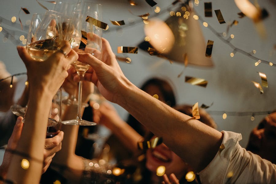 A close up shot of a group of people clinking their champagne glasses together.