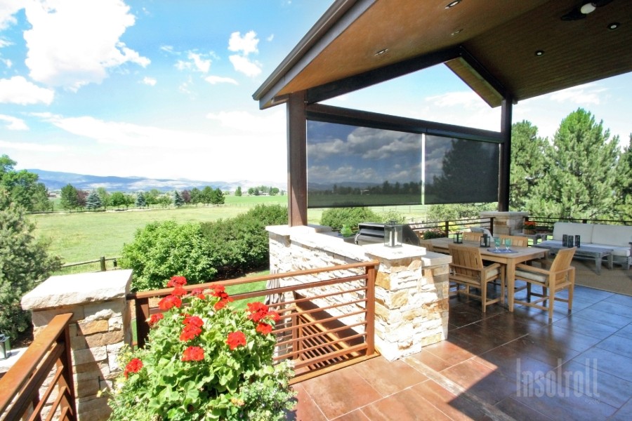 A patio with outdoor furniture and electric outdoor shades.